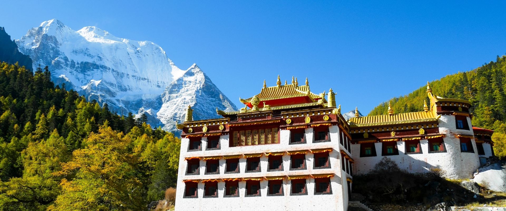Chonggu monastery with snow capped mountains
